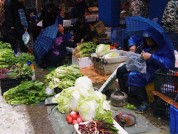 菜农冒雨摆摊街道 工作人员包圆：菜我全买了，你早点回家