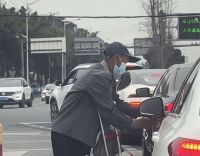 老人给路过的车辆系上红绳 温暖举动感动网友