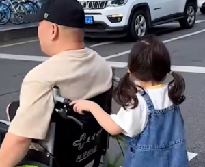 小女孩推爸爸过马路向让行的车辆鞠躬致谢