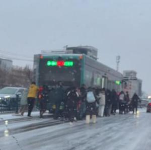 公交车雪中打滑 乘客集体推车 陌生肩膀汇聚暖流