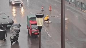 外卖小哥冒雨挪井盖 路人接力帮忙 善举温暖人心