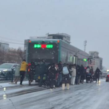 公交车雪中打滑 乘客集体推车 陌生肩膀汇聚暖流