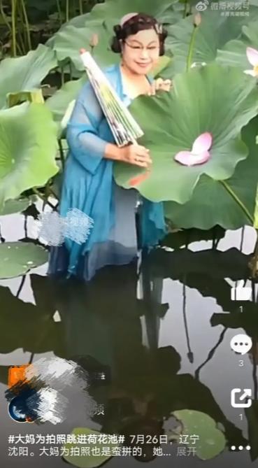 大妈跳进荷塘摘花拍照引热议 出淤泥而全染,摘花瓣被说糟!
