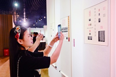 参观者在第五届海峡两岸中青年篆刻大赛作品展现场拍照。新华社发