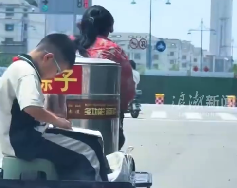 母亲卖粽子孩子三轮车上学习 网友：一边是生活，一边是希望