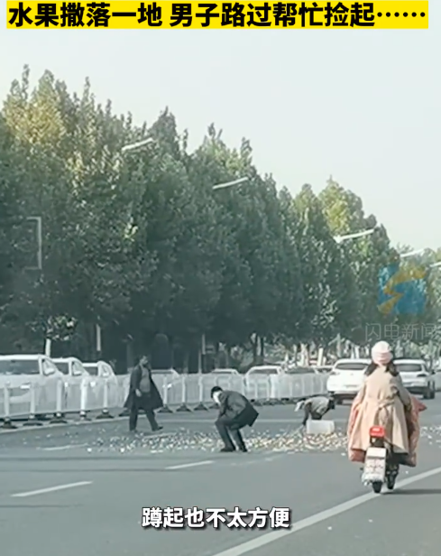西装男车流中帮大爷捡起一地水果