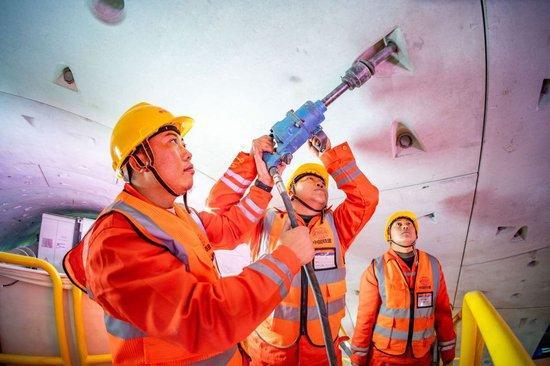 在中铁十四局京唐城际铁路运潮减河隧道内，施工人员在拼装管片（2024年2月4日摄）。新华社发（中铁十四局供图）