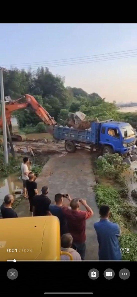 岳阳两辆满载卡车被推入河堵截洪水 紧急处置保家园