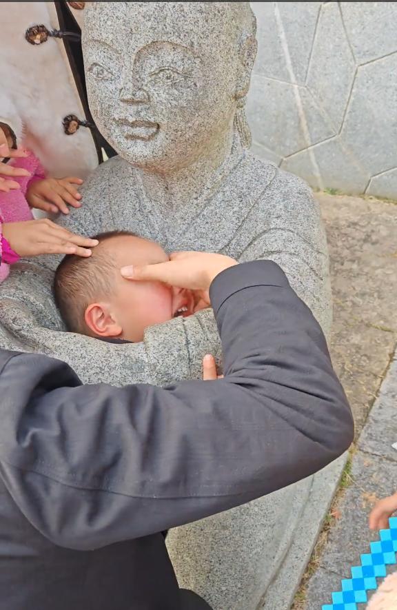 小孩一头扎进石像怀里出不来 家长回应:评论区笑不活了!