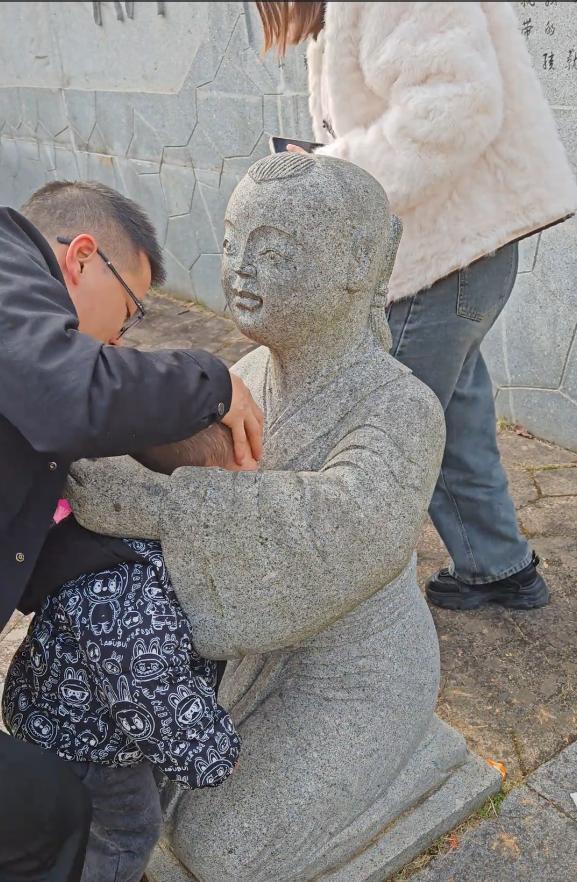 小孩一头扎进石像怀里出不来 家长回应:评论区笑不活了!