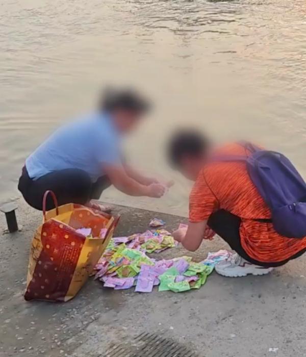 两女子往江里扔鱼豆腐 水务局工作人员回应