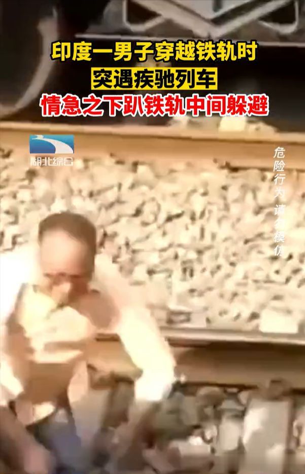 印男子穿铁路遇火车趴铁轨间躲避 虽然惊险但没受伤