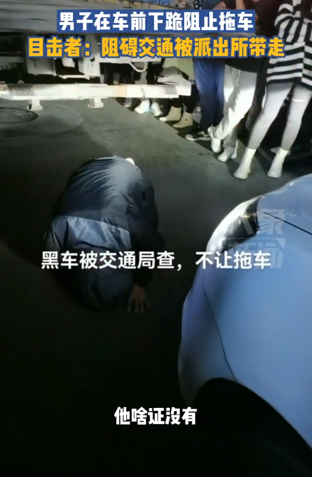 男子在车前下跪阻止拖车