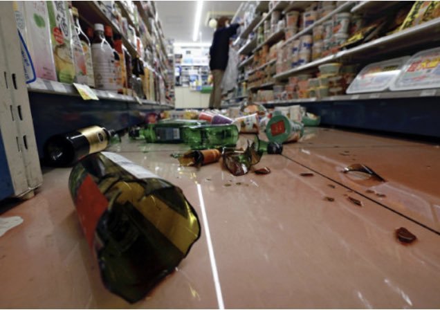 宫城县石卷市一家便利店在遭遇地震后,货架上的酒瓶砸落一地