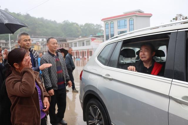 村民冒雨含泪送驻村书记 村民们有的提着东西、有的拿着锦旗
