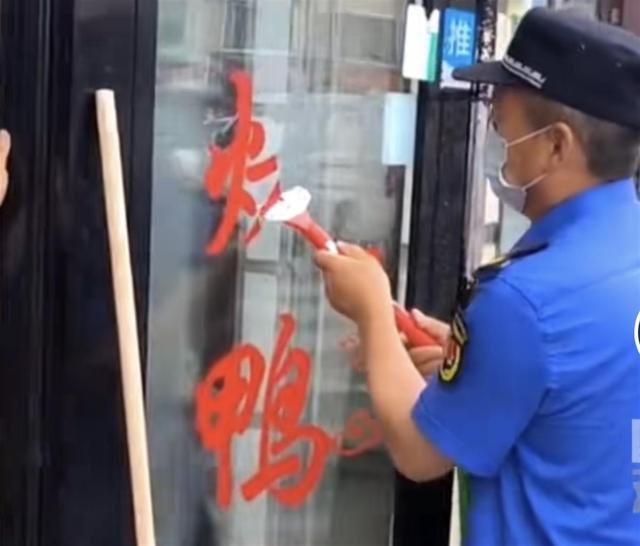 城管铲掉商户玻璃门红字，有人称检查会被扣分