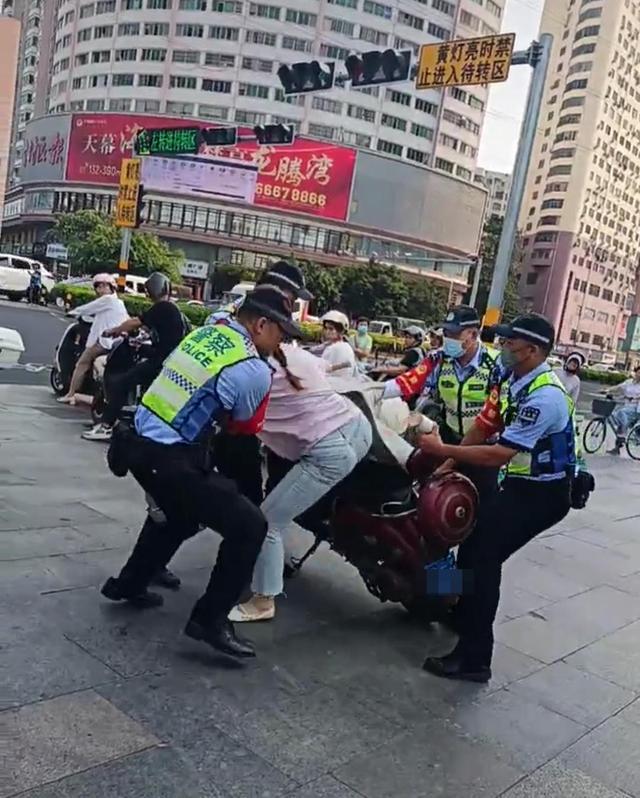 海口交警回应将女子拽下电动车 涉闯红灯，详情待通报