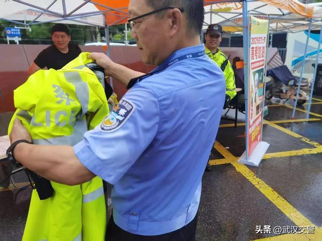 交警在大雨中为高考生撑伞 风雨无阻护考路