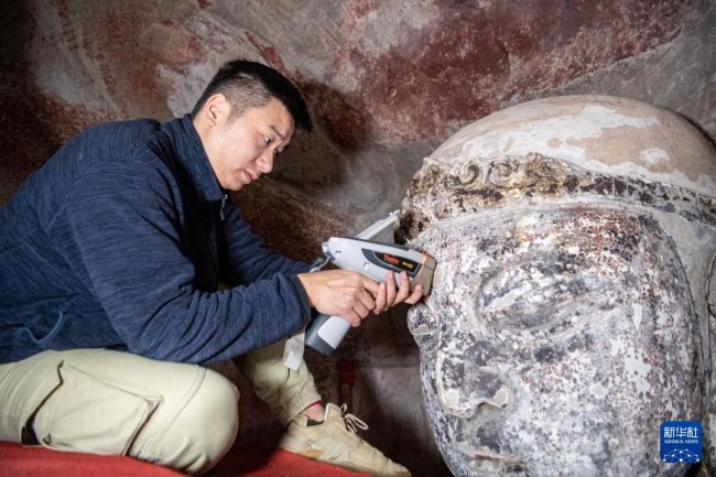　　11月12日，修缮工程现场技术员黄和然在分析检查造像矿物质成分。新华社记者 唐奕 摄