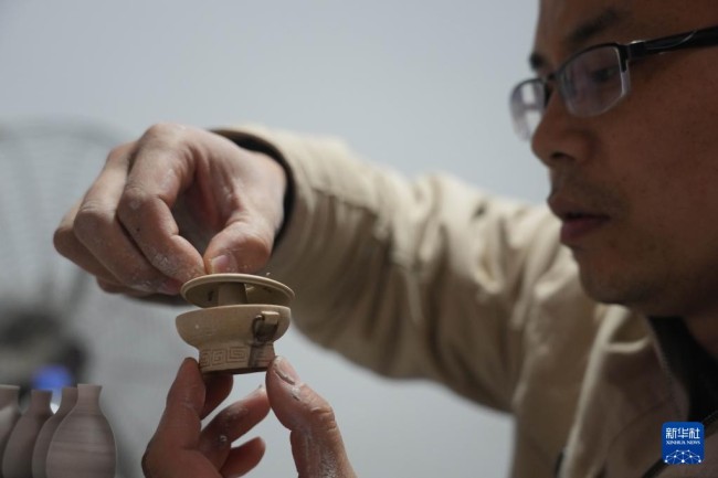 12月15日，王文化展示微型陶瓷火锅作品。
