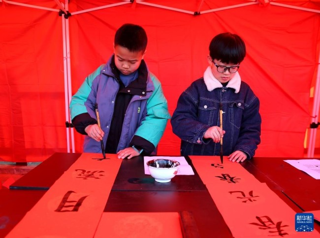 1月1日，小朋友在江苏省淮安市洪泽湖古堰景区写对联。