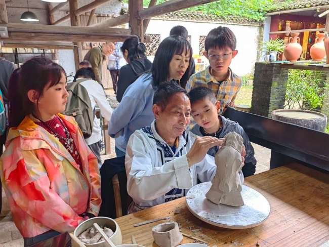 “五一”期间，江西景德镇古窑民俗博览区，非遗传承人向游客展示陶瓷制作技艺。 本报记者 舒 琳 摄