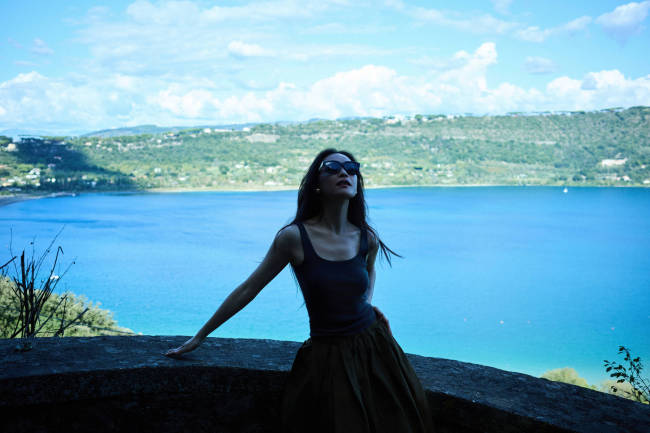 倪妮戴墨镜穿搭简约 在湖边张开双臂活力满满