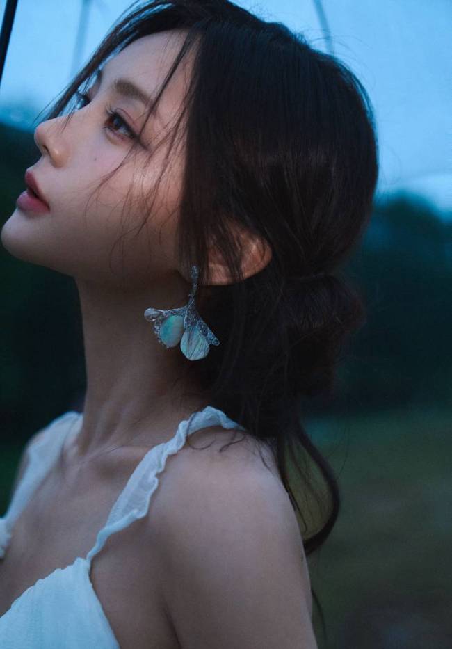 李一桐穿白色吊带裙身材窈窕 雨中撑伞氛围感十足