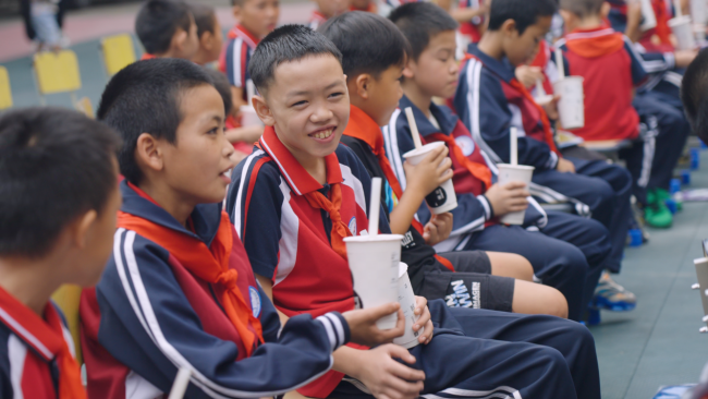 开学庆典上，学生们东说念主手一杯古茗奶茶，这份礼物让他们笑的很振奋