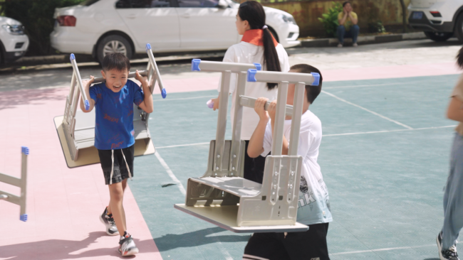 学生振奋的搬运属于我方的新课桌椅