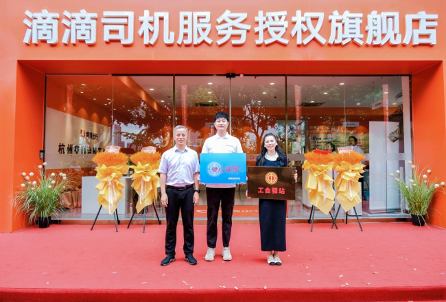 图为：杭州市总工会副主席凌卫洪为杭州旗舰店授牌“工会驿站”、“爱心驿家”