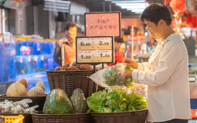 顾客在超市选购蔬菜。郭昊摄