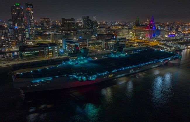 英国皇家海军“伊丽莎白女王”号航母停泊在利物浦，灯光营造出奇幻氛围。