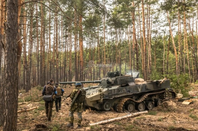 外媒摄影师作品：乌克兰士兵与被摧毁俄装甲车合影