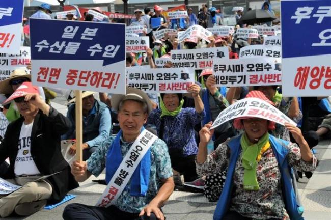 8月16日，在韩国全罗南道高兴郡沿海一带，韩国渔民手持标语参加集会活动，抗议日本核污染水排海计划。新华社记者 周思雨 摄