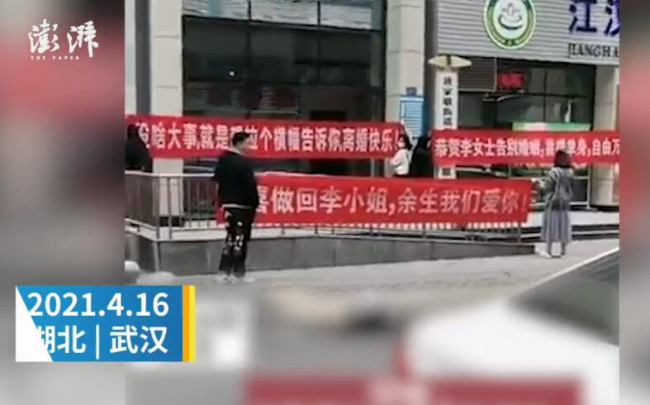 女子婚姻登记处办离婚 好友门外拉横幅庆祝