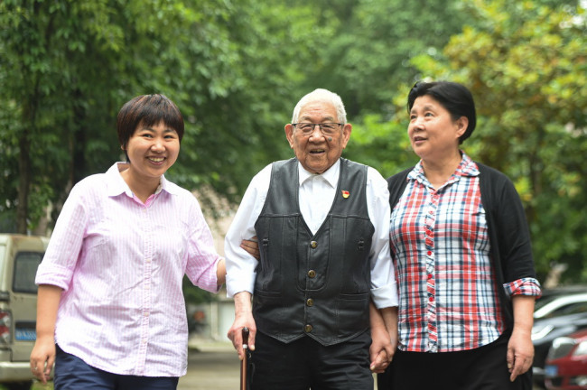 5月18日，胡兆富（中）与孙女胡煜琦（左）、女儿胡玲在小区内散步。