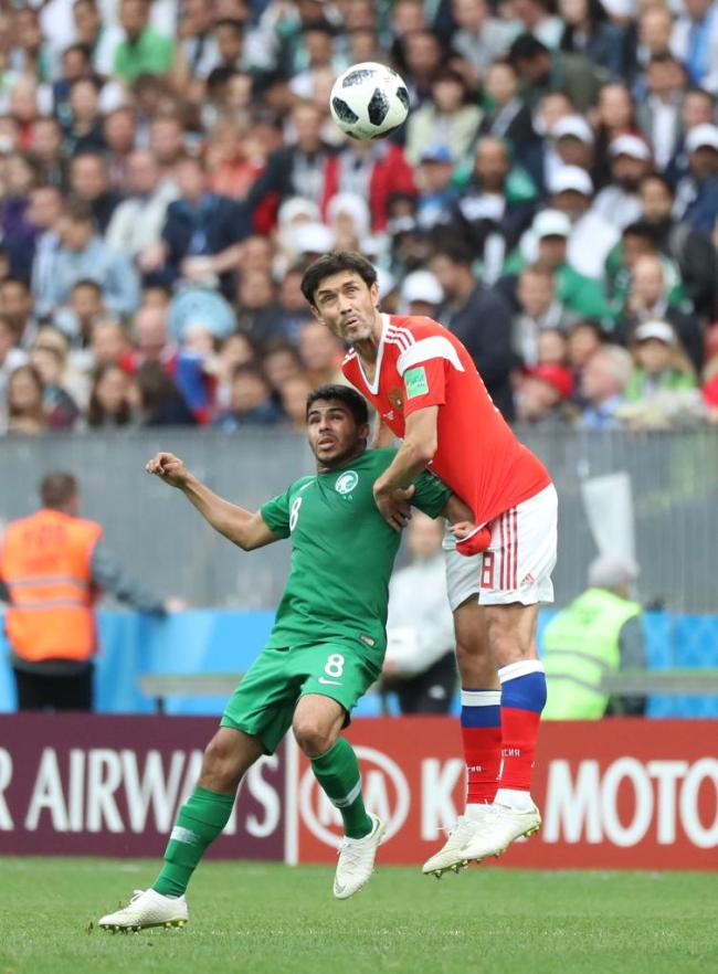 2018年6月14日，俄罗斯世界杯，俄罗斯队球员加辛斯基（右）与沙特阿拉伯队球员谢赫里在揭幕战中拼抢。新华社记者徐子鉴摄
