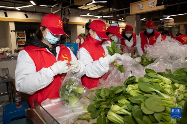 12月12日，浙江省绍兴市上虞区志愿者分拣打包青菜，准备向居家隔离的居民配送。