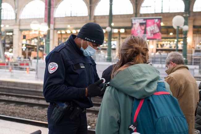 法国奥密克戎毒株感染病例数激增 边防警察检查旅客通行证