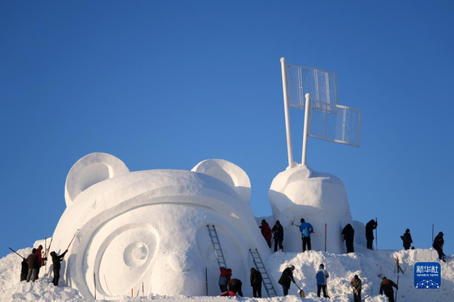 　12月24日，在太阳岛雪博会园区，雪雕师在进行雪雕创作。