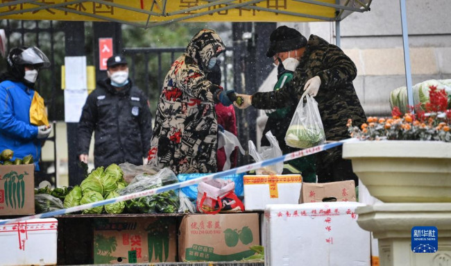 12月25日，西安市碑林区一封控小区的大门旁，开辟了蔬菜市场，方便市民选购。