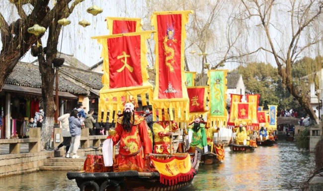 2022年2月5日，江蘇蘇州水鄉(xiāng)周莊雙橋,，五路“財(cái)神”們正在水巷給兩岸游客送財(cái)送祝福,。