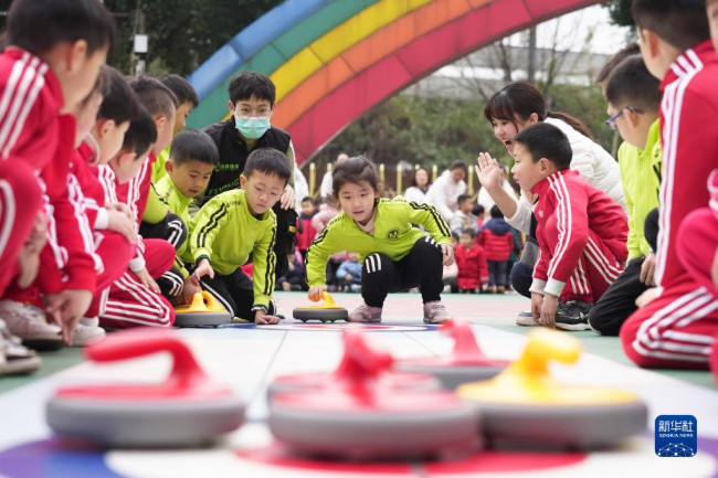 2月16日，在重庆市北碚区缙云幼儿园，孩子们在开学第一课上体验旱地冰壶。