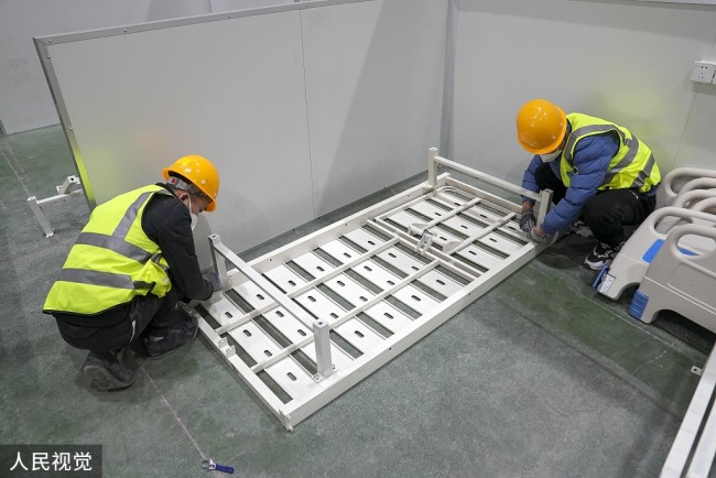 2022年3月12日，长春国际会展中心方舱医院正在建设中。施工现场，工人们正在进行床位安装和整体清扫工作。