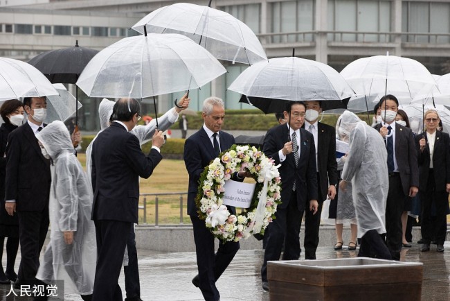 当地时间2022年3月26日，日本广岛市，日本首相岸田文雄与美国驻日本大使伊曼纽尔一同访问二战时被美国原子弹轰炸的广岛，在和平纪念公园献花。