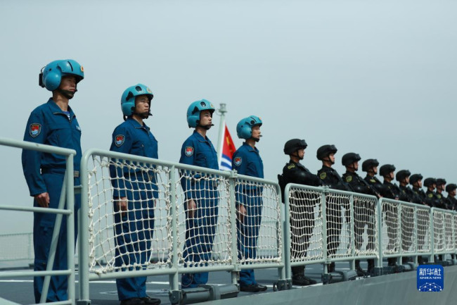5月18日，中国海军第41批护航编队在浙江舟山某军港解缆起航，随舰机组、特战队员在甲板上整齐列队。新华社发（徐巍 摄）