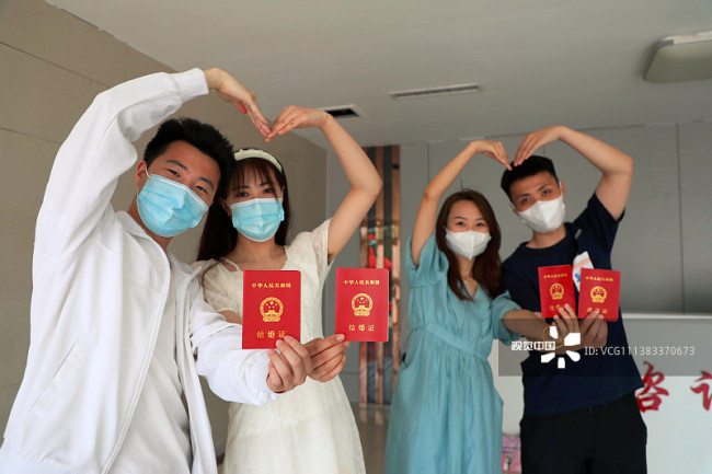 2022年5月20日，在山东省滨州市博兴县民政局婚姻登记处，两对同日登记结婚的新人在共秀“甜蜜”。