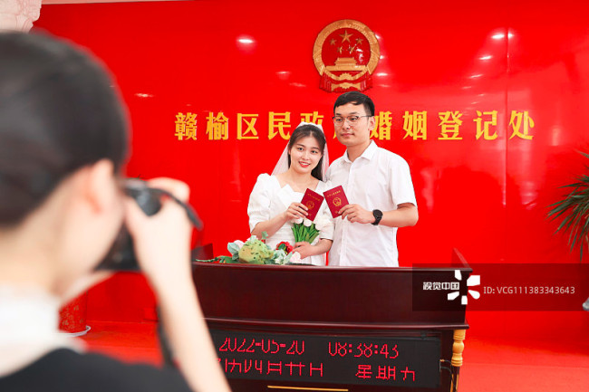 2022年5月20日，在江苏省连云港市赣榆区民政局婚姻登记处，一对新人在领证后拍照留念。