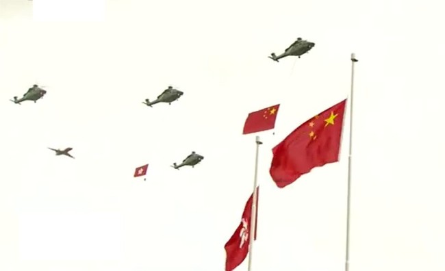 直升机挂国旗区旗飞过维多利亚港，消防处灭火轮在维港海面喷洒水柱敬礼